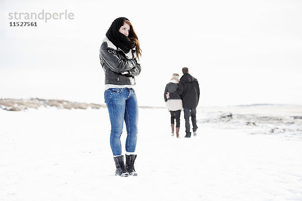 Frau steht im Winter  Paar im Hintergrund