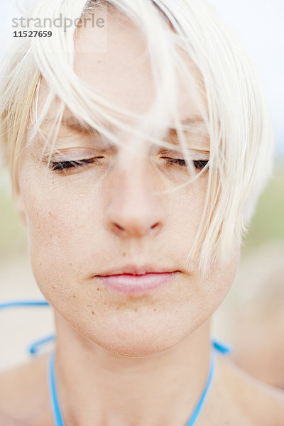 Porträt einer blonden Frau mit geschlossenen Augen