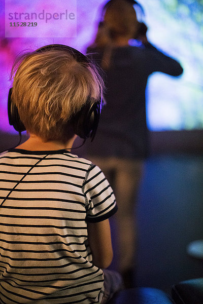 Kinder tragen Kopfhörer und hören Musik