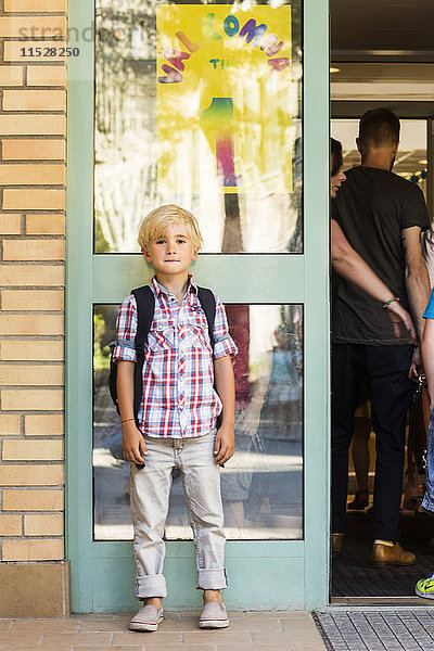 Junge vor dem Schulgebäude stehend