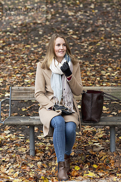 Lächelnde Frau auf einer Bank sitzend