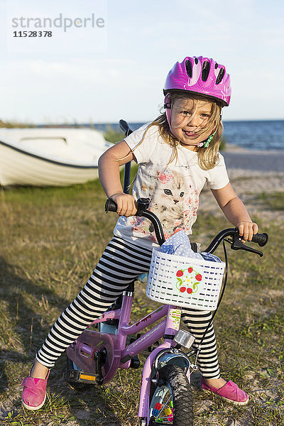 Mädchen auf Fahrrad am Strand