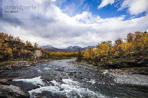 Fluss in hügeliger Landschaft