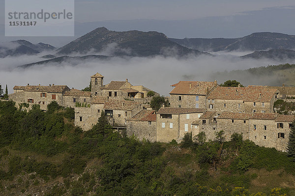 Frankreich  Drome  Provence  das Hügeldorf Poet-Sigillat am frühen Morgen  sonnig  mit Nebel und Bergen im Hintergrund