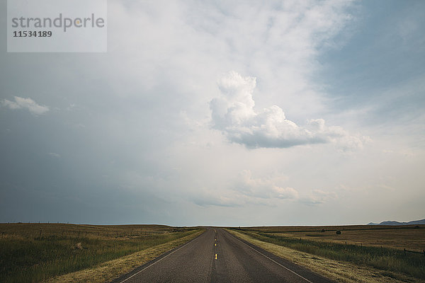 Eine Straße  die sich in einer flachen Landschaft bis zum Horizont erstreckt.