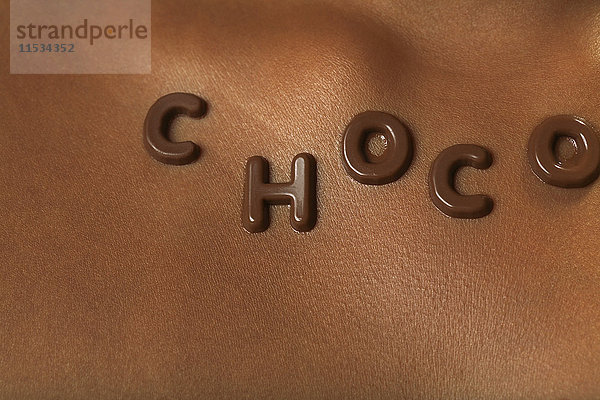 Nahaufnahme von Schokoladenbuchstaben auf der Brust einer Frau