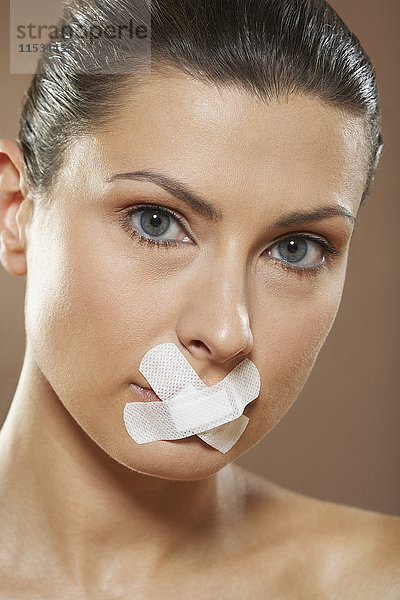 Frau mit Bandagen über dem Mund