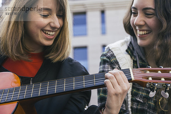 Frauen beim Gitarrespielen und Lachen