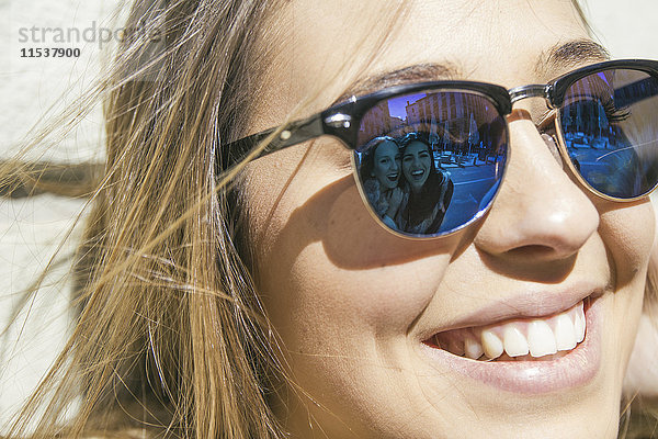 Freunde der jungen Frau reflektieren an ihrer Sonnenbrille