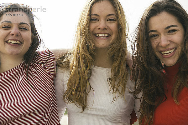 Porträt von drei glücklichen Frauen Arm in Arm
