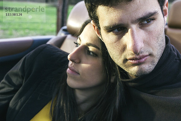 Porträt eines jungen Mannes mit seiner Freundin im Cabriolet