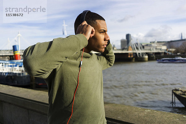 UK  London  Läufer hört Musik auf Riverwalk