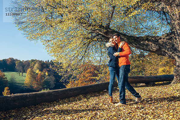 Glückliches Paar umarmt im Herbstwald
