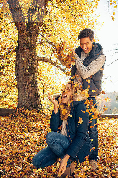 Ein glückliches Paar  das sich im Herbst im Wald amüsiert.
