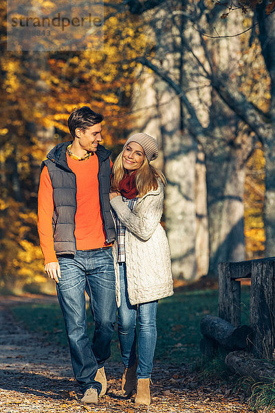 Glückliches Paar beim Herbstspaziergang im Wald