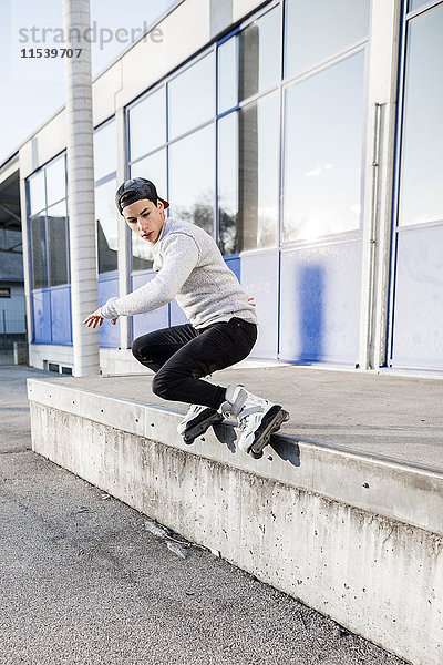 Junger Mann macht einen Trick auf Inline-Skates