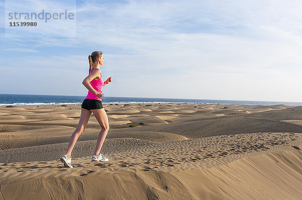 Junge Frau beim Joggen am Strand