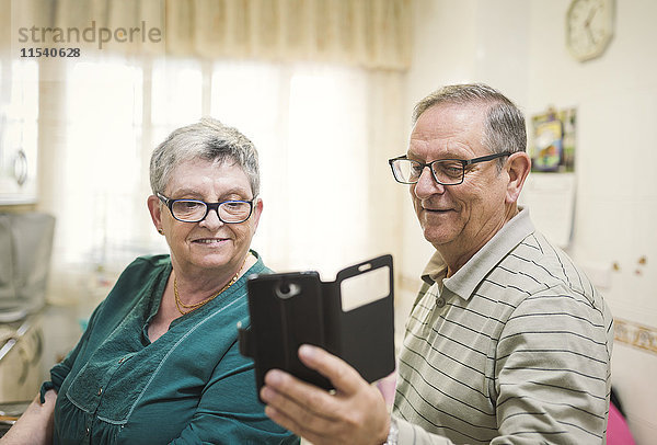Seniorenpaar sucht Smartphone zu Hause
