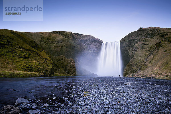 Island  Person vor dem Wasserfall von Skogafoos