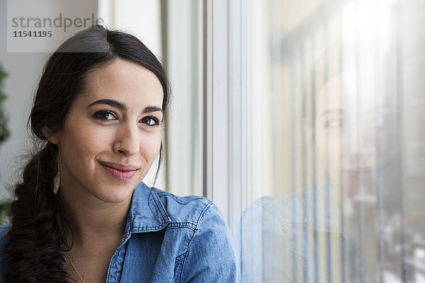 Porträt der lächelnden Frau am Fenster