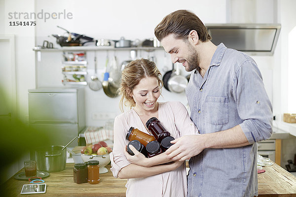 Paar mit Marmeladengläsern in der Küche