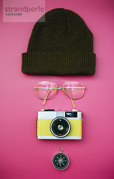 Gesicht von Wollmütze  Brille  Vintage-Kamera und Kompass