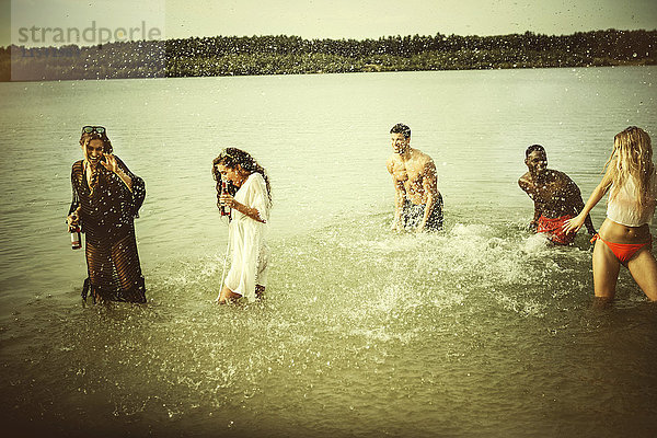 Deutschland  Haltern  Gruppe von fünf Freunden  die im Wasser des Silbersees stehen und sich amüsieren.