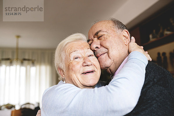 Zärtliche Umarmung eines älteren Paares zu Hause