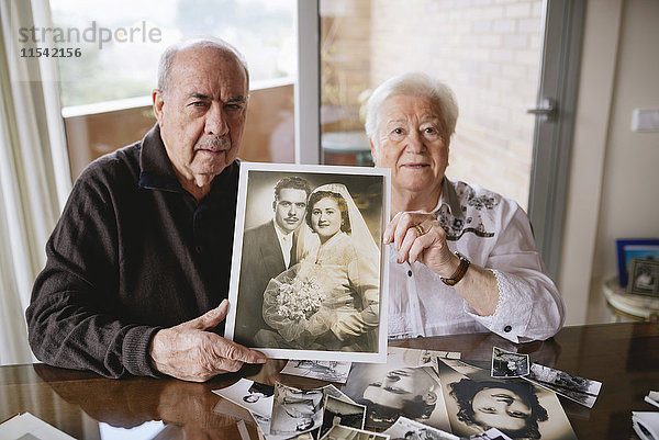 Seniorenpaar zeigt ihr Hochzeitsfoto zu Hause