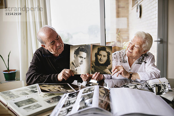 Seniorenpaar zeigt alte Bilder von sich selbst
