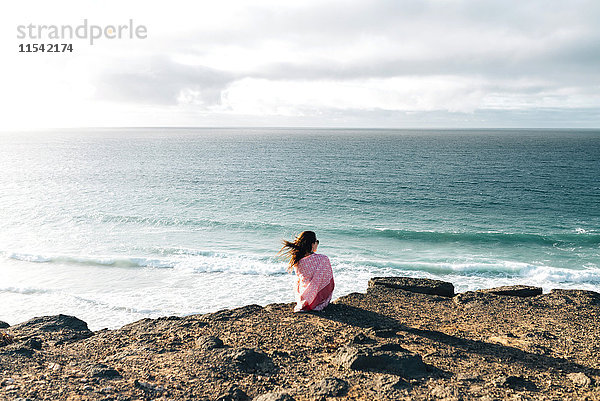 Spanien  Fuerteventura  El Cotillo  Rückansicht der Frau mit Blick aufs Meer