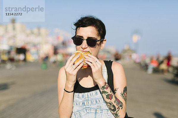 USA  New York  Coney Island  junge Frau beim Hamburgeressen