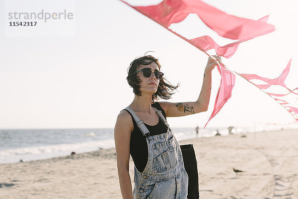 USA  New York  Coney Island  junge Frau mit roten Fahnen am Strand