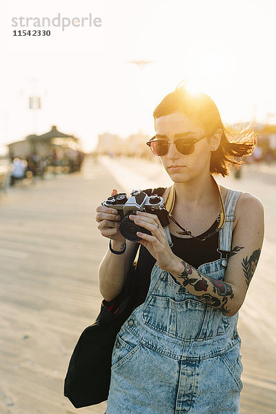 USA  New York  Coney Island  junge Frau schaut bei Sonnenuntergang in die Kamera