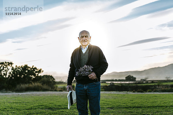 Spanien  Tarragona  älterer Mann mit Blumenstrauß auf dem Feld