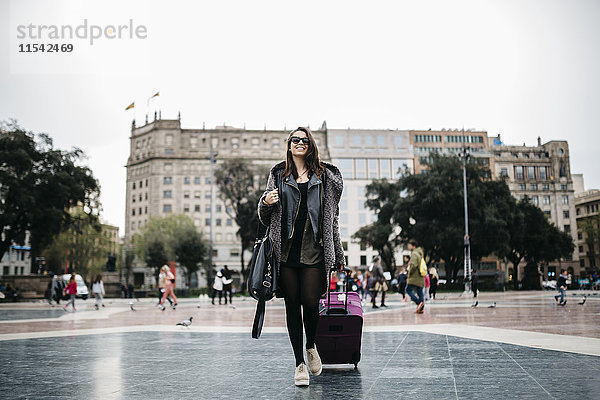 Spanien  Barcelona  junge Frau mit Koffer auf dem Placa Catalunya