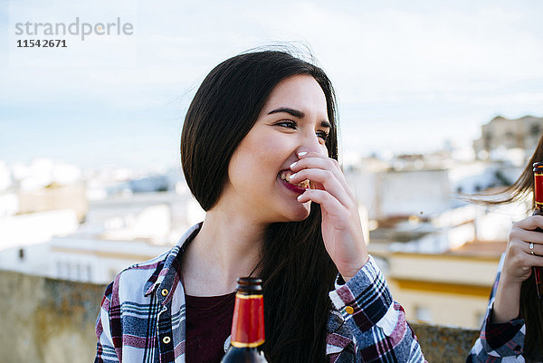 Spanien  Jerez de la Frontera  Porträt der lachenden jungen Frau mit Bierflasche