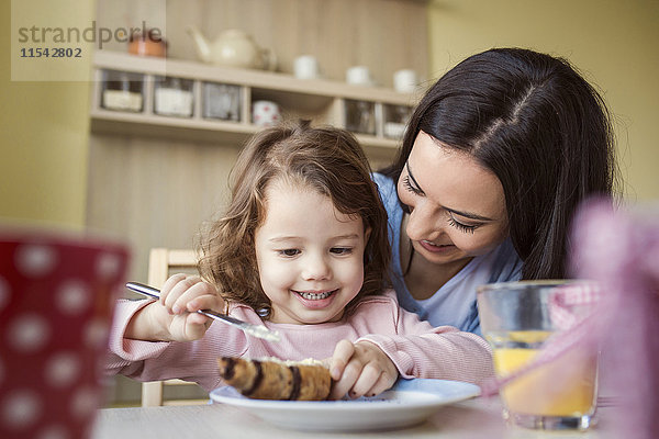 Porträt des kleinen Mädchens und ihrer Mutter am Frühstückstisch