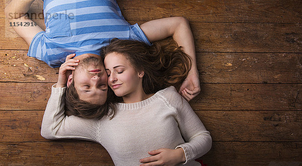 Verliebtes junges Paar entspannt sich gemeinsam auf dem Holzboden