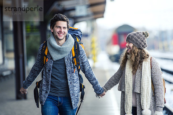 Glückliches junges Paar auf dem Bahnsteig
