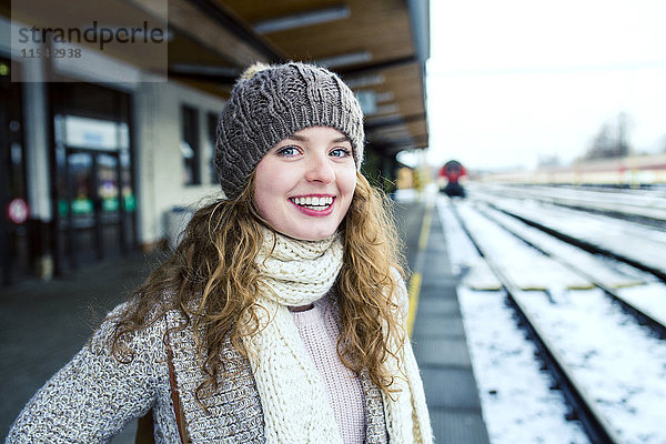 Porträt eines lächelnden Teenagermädchens auf dem Bahnsteig