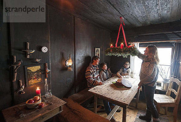 Eltern mit zwei Kindern in einem Bauernhauszimmer im Advent