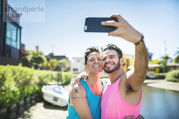 Los Angeles  Venedig  fröhliches schwules Paar  das sich mit dem Smartphone selbstständig macht.