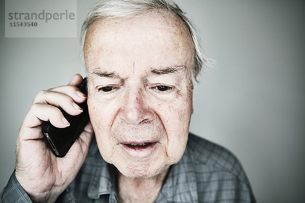 Porträt eines älteren Mannes beim Telefonieren mit dem Smartphone