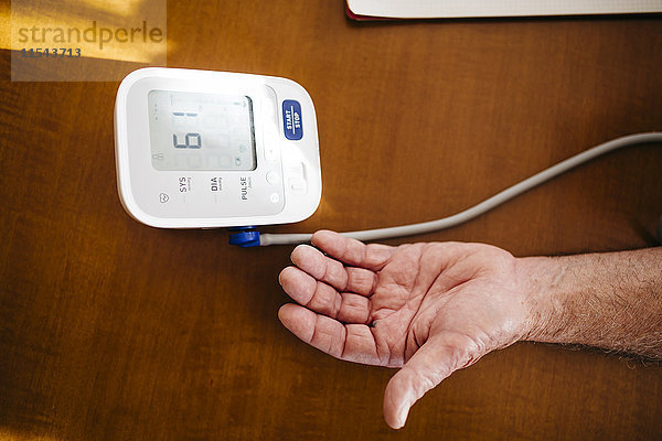 Hand des älteren Mannes mit Blutdruckmessgerät  Nahaufnahme
