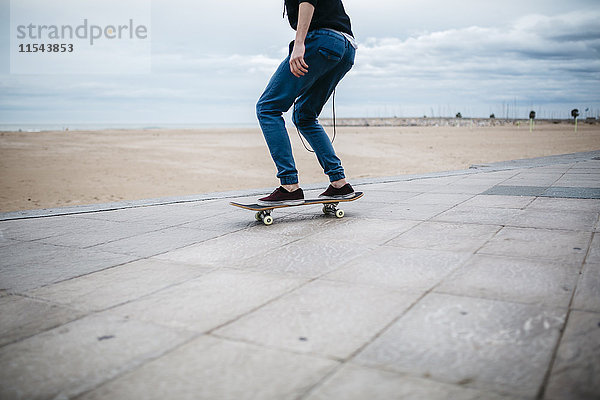Spanien  Torredembarra  junger Skateboarder vor dem Strand  Teilansicht
