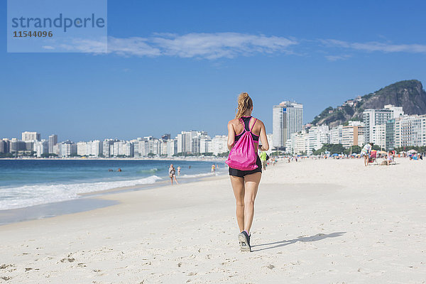 Brasilien  Rio de Janeiro  Rückansicht der Frau beim Joggen am Strand