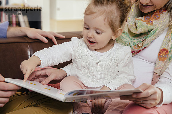 Eltern lesen Buch für kleines Mädchen
