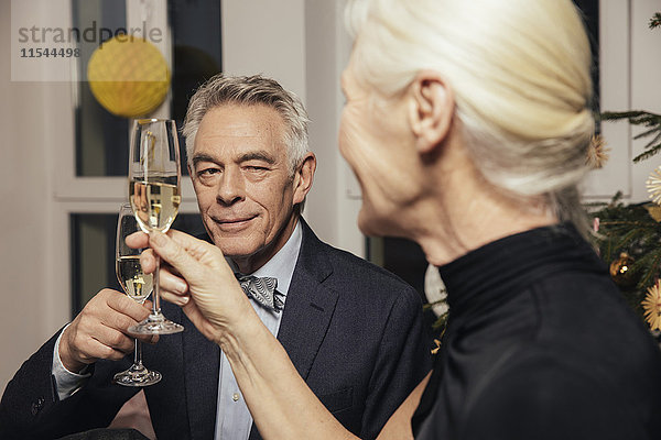 Seniorenpaar klirrt mit Champagner an Silvester