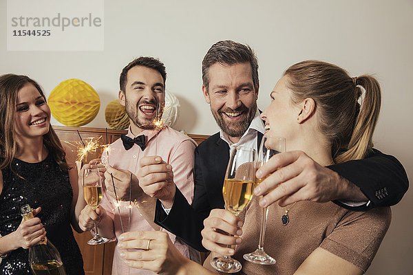 Freunde feiern gemeinsam Silvester und trinken Champagner.